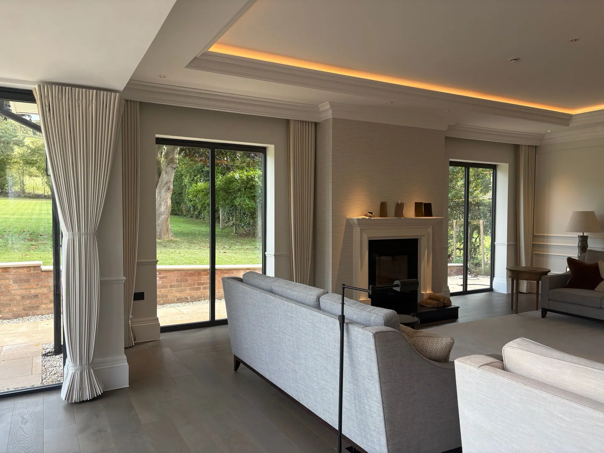Pleated cream curtains beside garden doors in an elegant living room